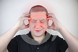 A man holds his head with his hands. Sensation of headache, migraine and dizziness. Headaches from stress or overwork