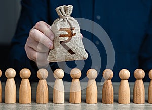 A man holds a indian rupee money bag above the crowd.Salaries.