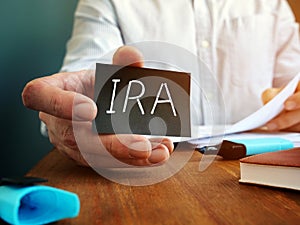 Man holds Individual Retirement Account IRA sign on the sheet photo