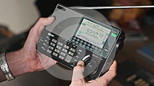 Man Holds Modern Portable Radio With Digital LCD Scale and Scans Radio Stations