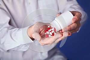 Man holds multi-colored pills in hands. Panacea, life save service, prescribe medicament, legal drug store, disease healing