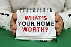 A man holds a notepad in his hands with the inscription - What is your home worth