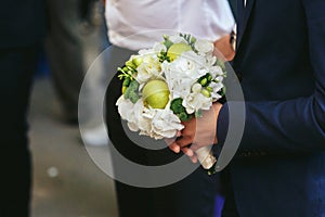 Man holds an original wedding bouquet made of white flowers and