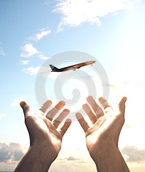 Man holds out his hands to a flying plane