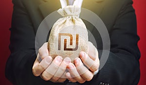 Man holds out a Israeli shekel money bag. Budget management, collect taxes. Bank issuance of credit and loans borrowings