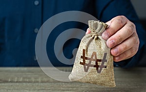A man holds out a south korean won money bag.