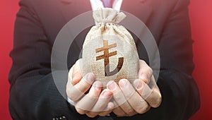 A man holds out a turkish lira money bag. Bank issuance of credit and loans borrowings to business. Financial crisis support