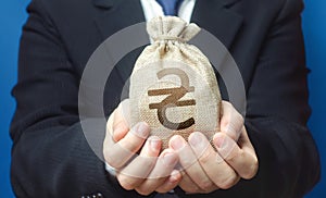 A man holds out a ukrainian hryvnia money bag. Trade, economics. Granting financing business project or education. Provision cash