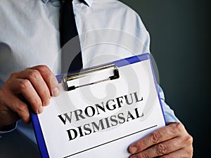 Man holds papers about Wrongful dismissal