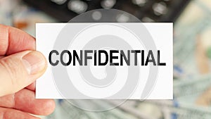 A man holds a piece of paper with the text: CONFIDENTIAL. Business and finance concept