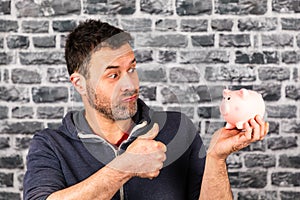 Man holds a piggy bank in his hand