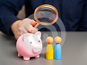 A man holds a piggy bank in his hands near people of Ukrainian nationality.