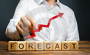 Man holds red arrow up over word Forecast. A budget surplus, prosperous economy or company. Prediction of profit growth, value