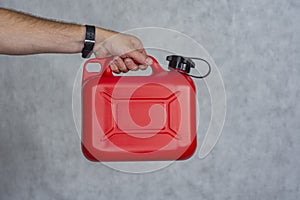 Man holds a red plastic gas canister in his hands