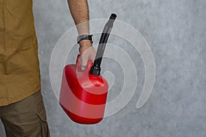 Man holds a red plastic gas canister in his hands