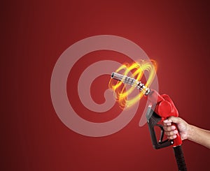 Man holds a refueling gun in his hand for refueling cars isolated on red background