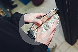 A man holds rubles and dollars in his hand, a businessman holds money in his hand.