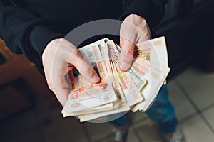 A man holds rubles and dollars in his hand, a businessman holds money in his hand.