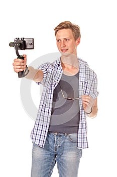 Man holds small action camera on gimbal.