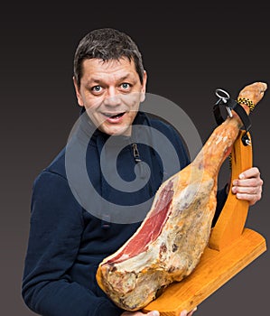 Man holds a Spanish Serrano ham. photo