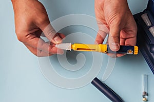 A man holds a syringe for subcutaneous injection of hormonal drugs in the IVF protocol & x28;in vitro fertilization& x29;. Medical