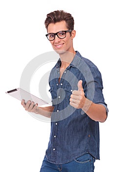 Man holds tablet & shows thumb up