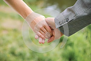 A man holds a woman`s hand. Hands of the bride and groom with an engagement ring close-up