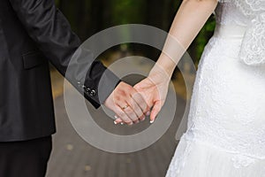 A man holds a woman`s hand. Hands of the bride and groom with a wedding ring close-up
