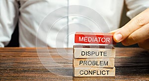 A man holds wooden blocks with the word Mediator, dispute, problem, conflict. Settlement of disputes by mediator. Dispute photo
