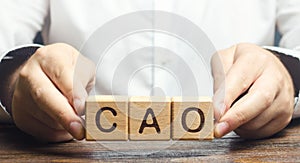 Man holds the word CAO in hands. Manage taxes and payroll. Develop and upgrade finance systems in business. Chief Accounting