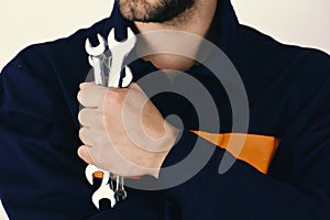 Man holds wrench tools isolated on white background. Mechanic or plumber with metallic spanners equipment in hand.