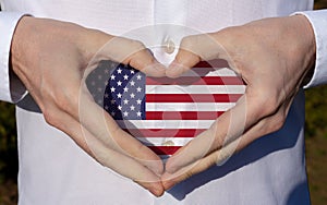 man holidng his hands in heart shaped on white shirt with usa flag colors national holiday concept