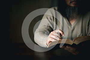 Man with holy bible in his hand, ready to pray, seek guidance from God through religious prayer. Person man, turned to God in