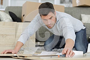 man at home assembling flat pack furniture