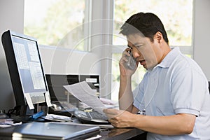 Man in home office with computer and paperwork