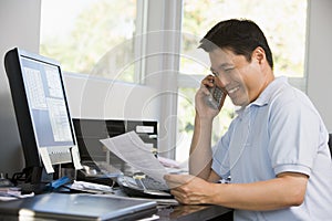 Man in home office with computer and paperwork