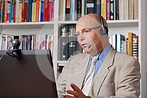 Man in home-office talking via skype photo