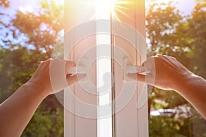 man at home open window on a sunny day. manual open white pvc plastic window at home