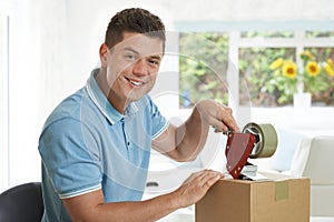 Portrait Of Man At Home Sealing Box For Dispatch