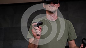 Man At Home Wearing Virtual Reality Headset Holding Gaming Controllers. Active VR Game Virtual Reality Technology Gaming