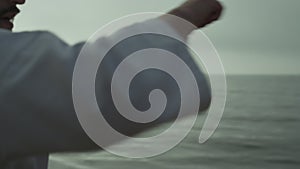 Man honing fighting skills training punches standing beach at sunrise close up.