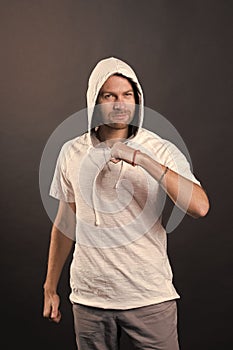 Man in hood with clenched fist gesture. Bearded man in casual sweatshirt. Fashion model in hoodie tshirt. Active