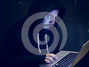 Man with hood in computer hacking shoot