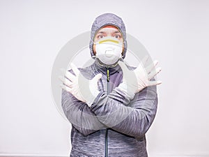 Man with hood and mask has his arms crossed showing gloves as part of the individual protection equipment