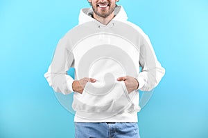 Man in hoodie sweater on color background
