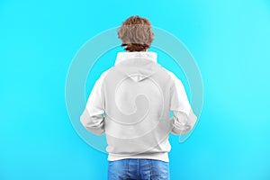 Man in hoodie sweater on color background