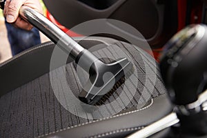 Man Hoovering Seat Of Car During Car Cleaning