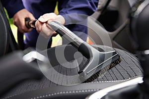 Man Hoovering Seat Of Car During Car Cleaning