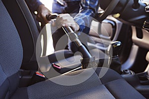 Man Hoovering Seat Of Car During Car Cleaning