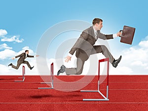 Man hopping over red treadmill barrier